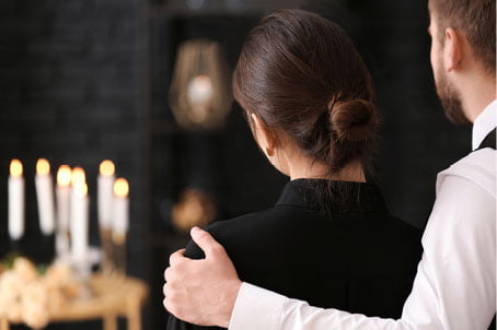 Adapting to Rising Cremation Trends 2 man's hand on woman's shoulder at funeral